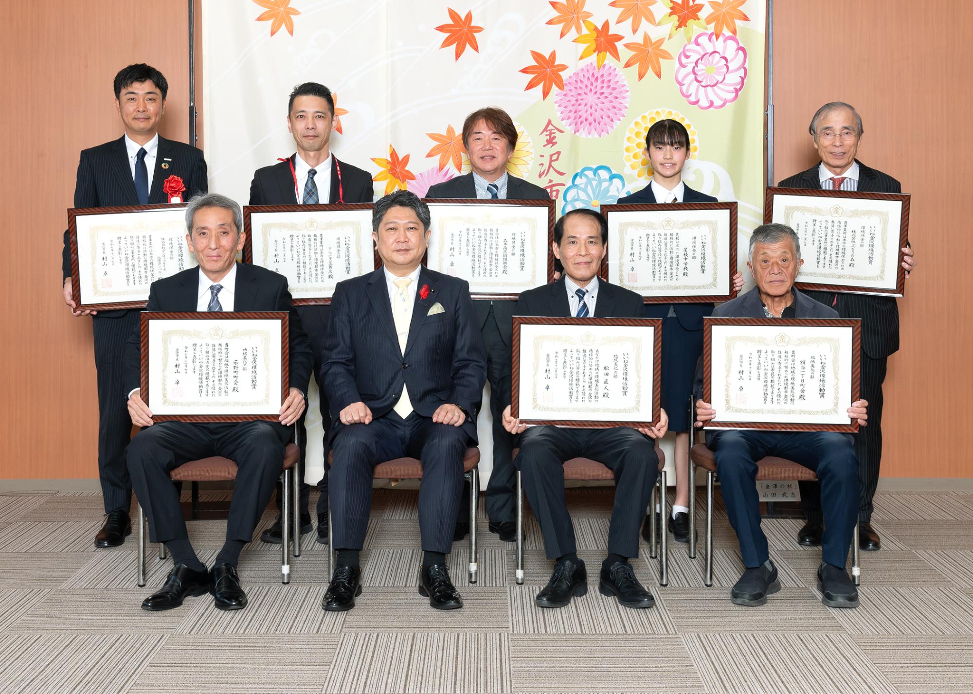 いいね金沢環境活動賞表彰式にて市長と受賞者4名がお立ちになっています。受賞者はそれぞれ手に賞状を持ち、記念撮影をしています。