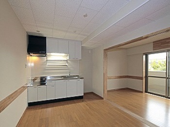 フローリングと白い色で統一された台所が写っている室内の写真