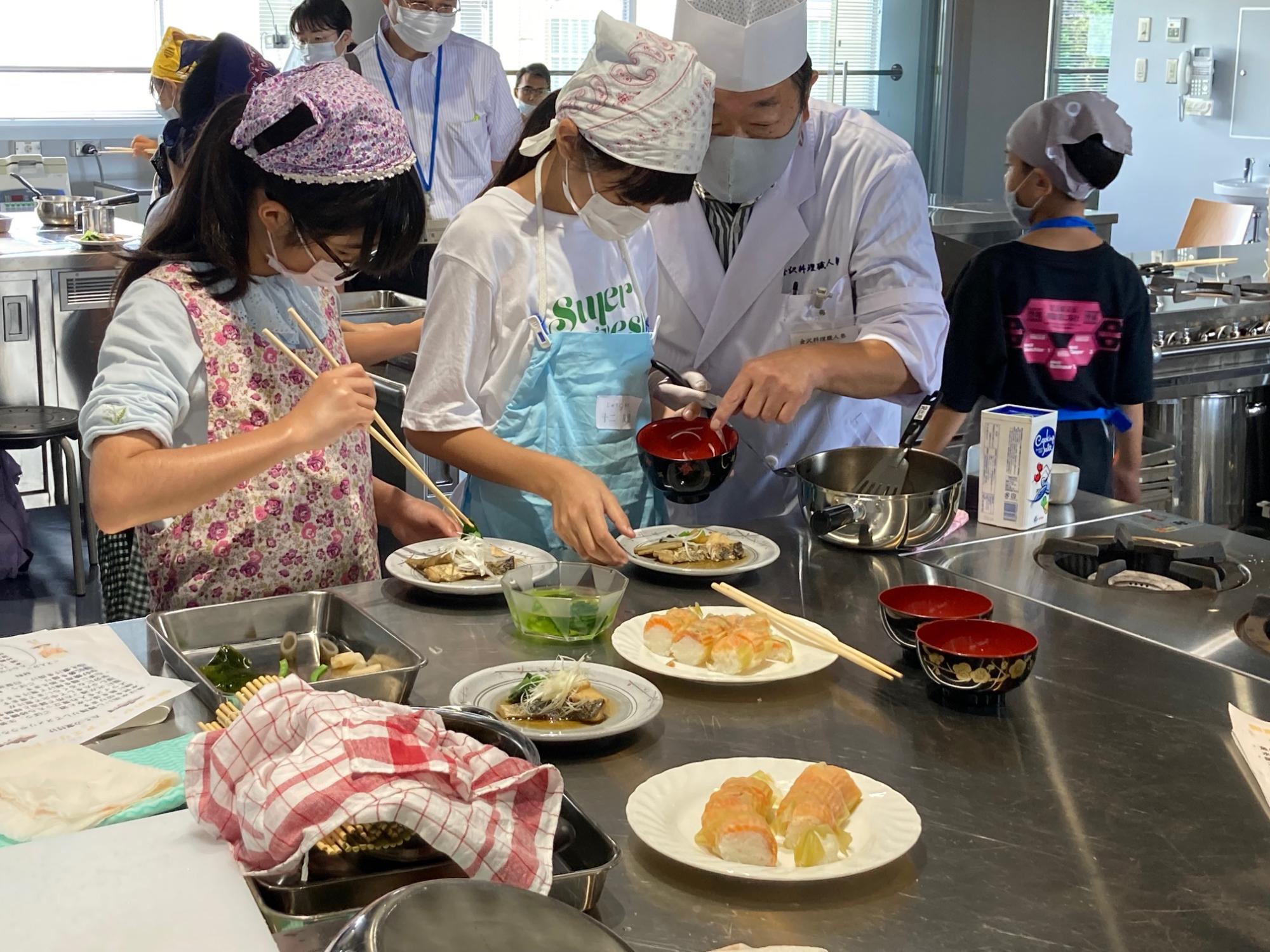 金沢の熟練の料理人が子どもたちに料理を教えている様子
