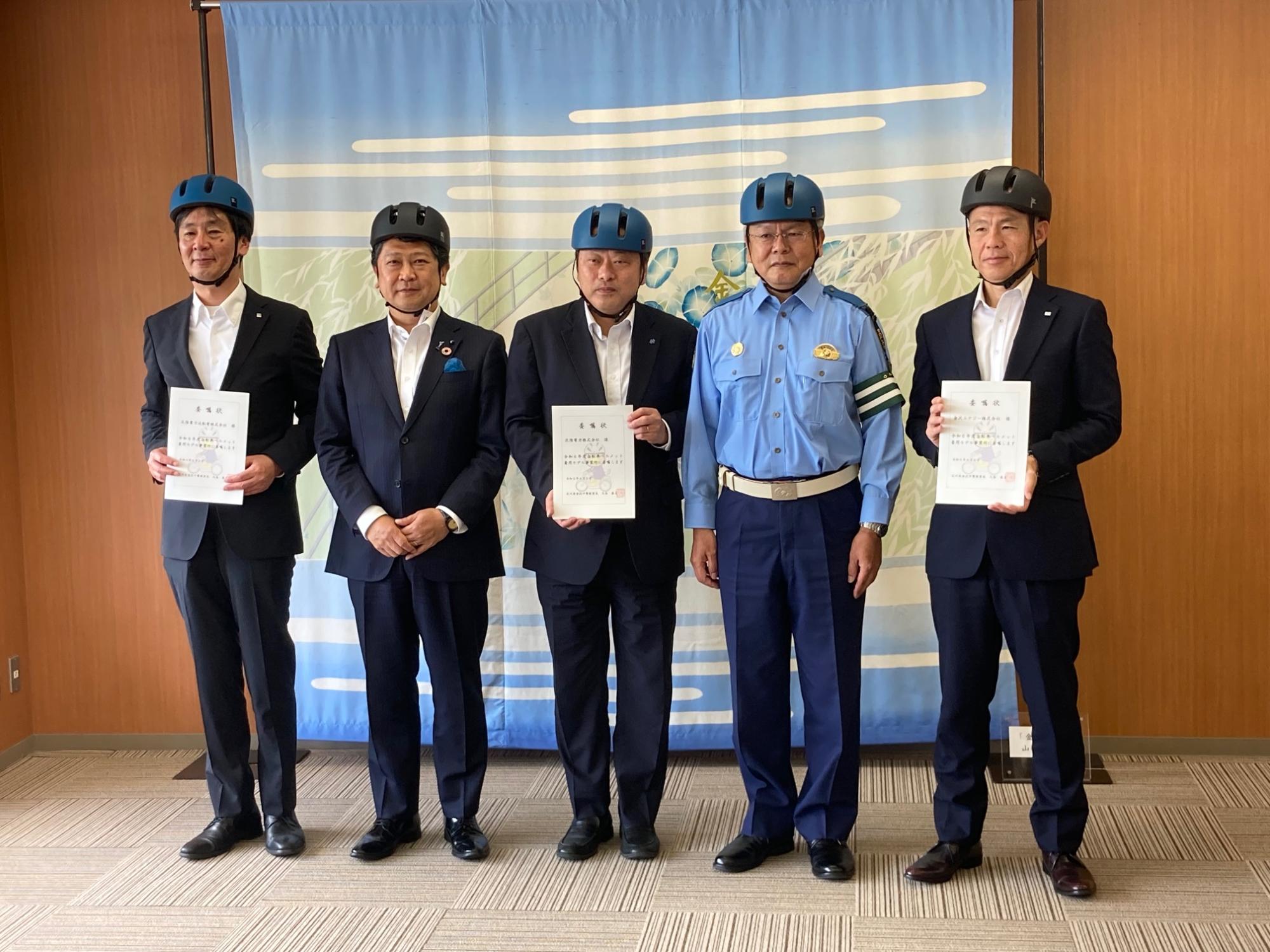 金沢中警察署からの委嘱状交付、金沢市からヘルメット等の贈呈の様子