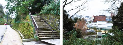 左側には石で出来た階段、右には草木の間から見える街並みが写っている写真