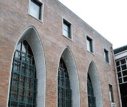 縦長で半円形の窓が3つとその上に4つの長方形の窓がある建物の外観写真
