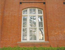 周りはレンガ調の壁で囲まれ、中央に白い窓がある図書館外観の写真