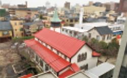白い壁に三角の赤い屋根がある屋敷を上から写している写真