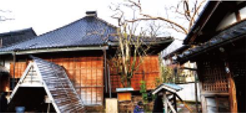 茶色の木で造られた壁と瓦の屋根で出来ている家のような建物が写っている写真