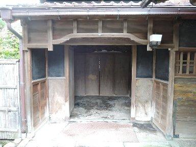 下屋庇にサガリを付けた木造建築の玄関の写真