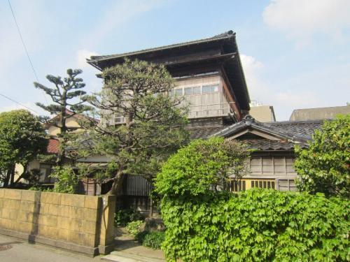 松の木や緑に囲まれた、木造2階建て、近代和風建築の佐藤家住宅主屋の写真