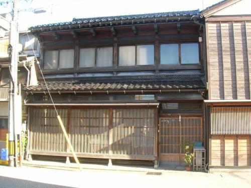 木造2階建ての出桁造の大屋根で2階に大きな窓のある、澁江家住宅主屋の写真