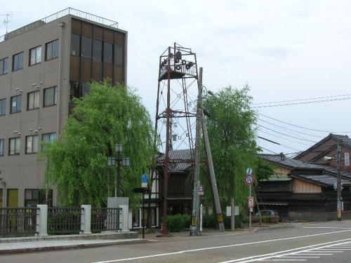 柳の木の間にある高さ11メートルの浅野川大橋詰火の見櫓の写真