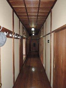 廊下の両側に部屋がある奥へと続いている中廊下の写真