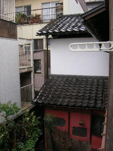 上部の外壁が白、下部の外壁が朱色の上野家住宅土蔵を高い位置から写した写真