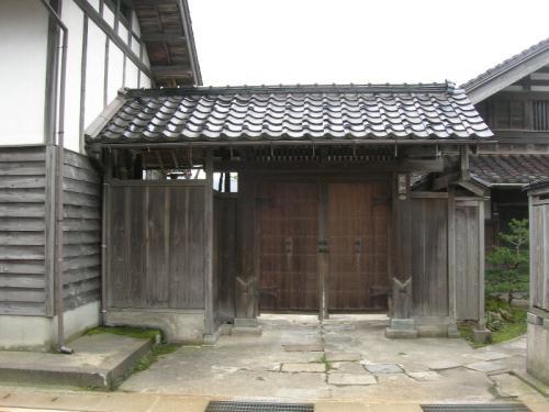 建物に接した、桟瓦葺の菊知家住宅表門の写真