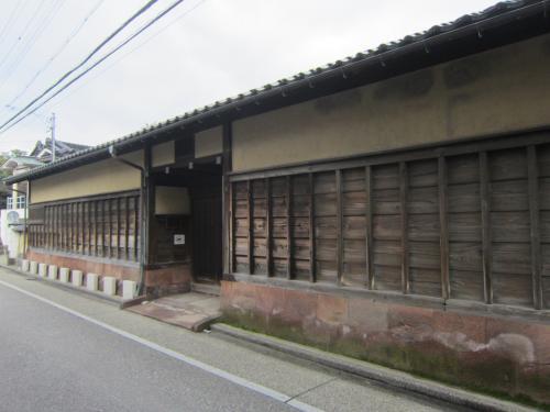 格子を入れて見た目を軽やかにし、足元の敷石の方向は縦に揃えてある、旧加賀藩士高田家長屋門の写真
