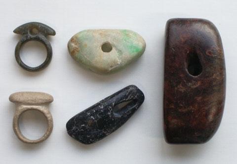 左から指輪型石製品2個、垂飾2個、大珠1個の写真