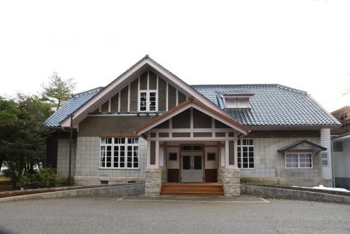 瓦屋根で、外壁が四角のブロックで、升目上の窓がある石川県立美術館広坂別館の外観写真