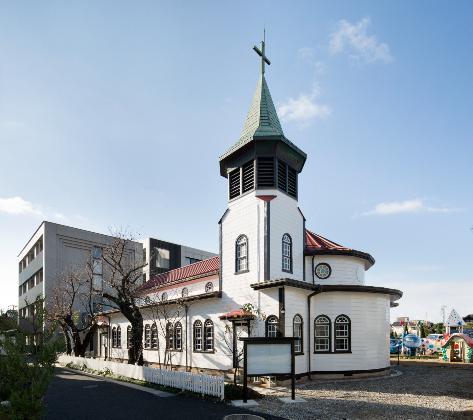 十字架を頂く尖塔がそびえ立つ聖霊病院聖堂の外観正面写真