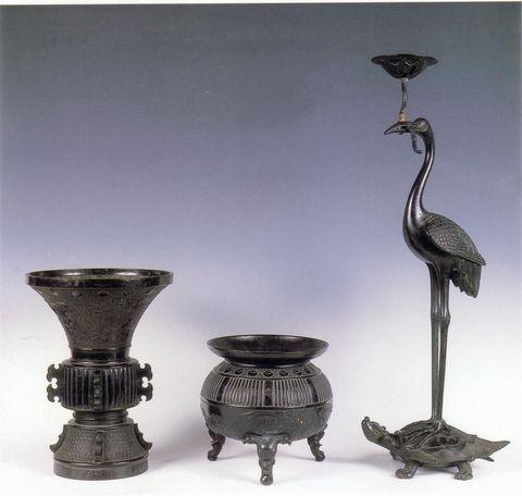 鋳造三具足(左から雲竜を文様化した花瓶、雲竜を文様化した香炉、亀の上に鶴が乗っている鶴亀燭台)の写真