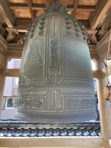 正面から撮影した青銅色の梵鐘アップの写真
