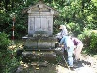 ボランティアの方3名が野田山・前田家墓所の石造物の前で記録をとっている様子の写真