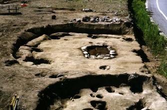 土が掘り起こされ、遺跡の後が形どられて、所々に穴の形がある東市瀬遺跡から見つかった竪穴住居跡の写真