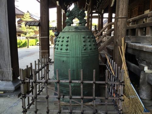 竹を組んで出来た柵の中にある本願寺金沢別院所蔵の時鐘の写真