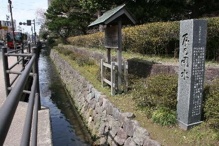 金沢くらしの博物館前、右側に石積、左側に歩道と手摺を挟んだ用水路が辰巳用水