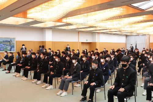 間隔を空けて設置された椅子に学生が座っている表彰式会場内の写真