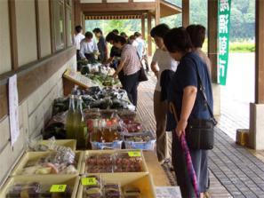 販売所に並べられた野菜や加工品を来場者の方が見ている写真