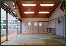 畳の敷かれた和室で左側が全面窓ガラスになっており、明るい光が差し込んでいる健康管理育児室の写真