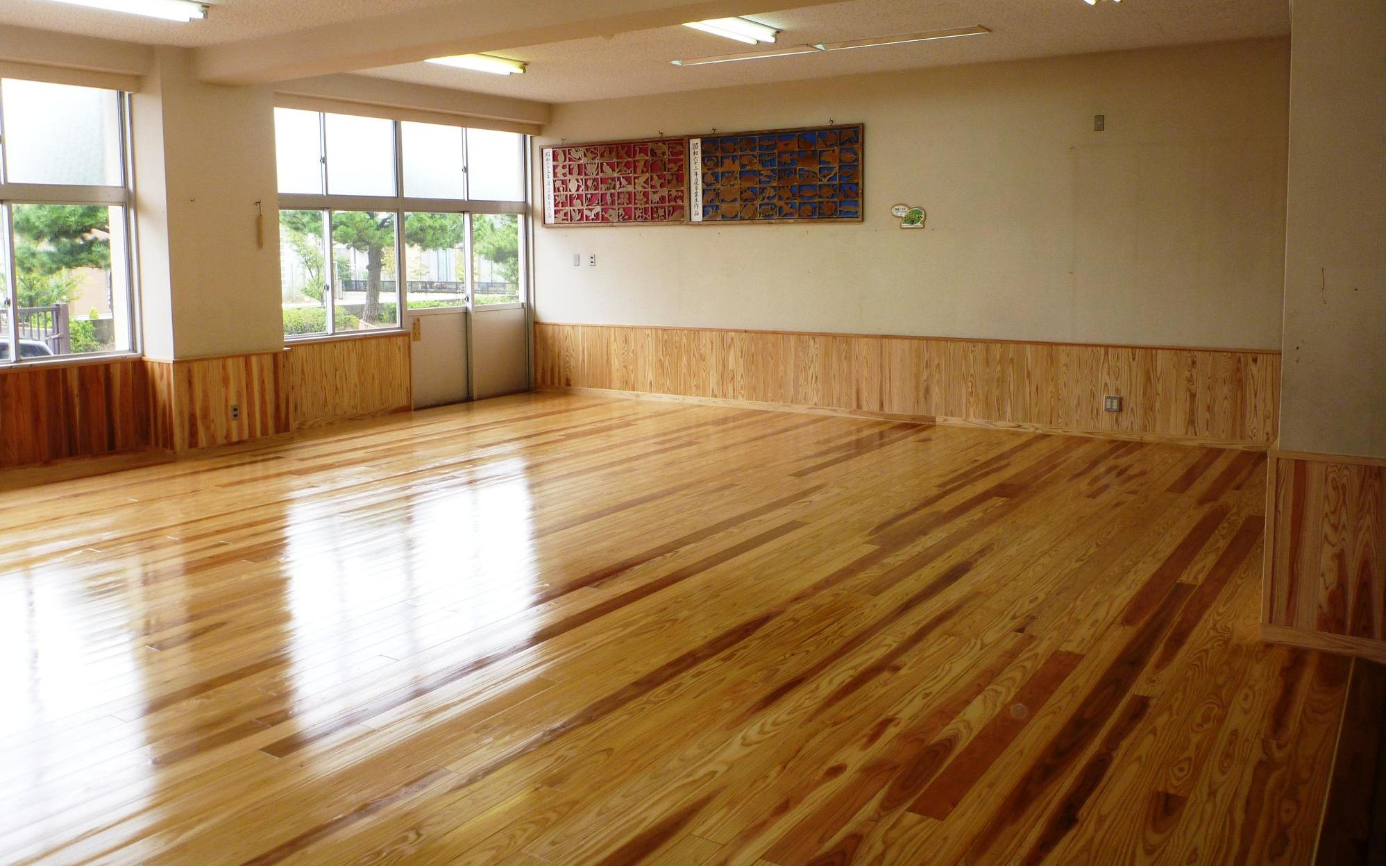 教室の床一面に真新しい板張りの床がある写真