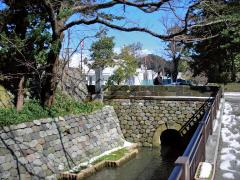 手前に金沢城の石堀があり、奥に金沢21世紀美術館が見える写真