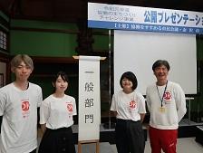 金沢工業大学・DK art caféプロジェクトの関係者4人が「一般部門」と書かれためくり台の横に立っている画像
