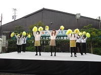 部隊の上で黄色のポンポンを持ち踊っている学生達の写真