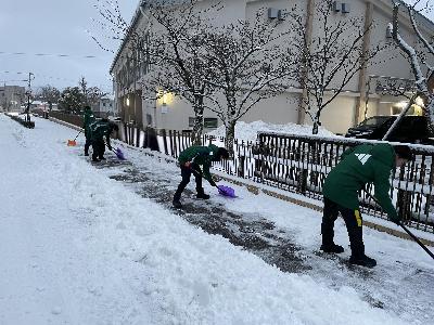 北陸大学サッカー部が田上地区町会連合会の区域内で雪かきをしている様子