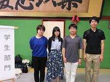 「学生部門」と書かれためくり台の横に立つ「金澤町家学生会議」の関係者4名が並んでいる写真