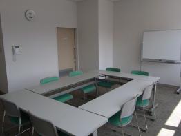 ロの字型に並べられたテーブルと椅子が並んだ、研修室の写真