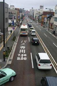 車が多く通る道路に「バス専用7.30-9.00」と書かれている様子の写真