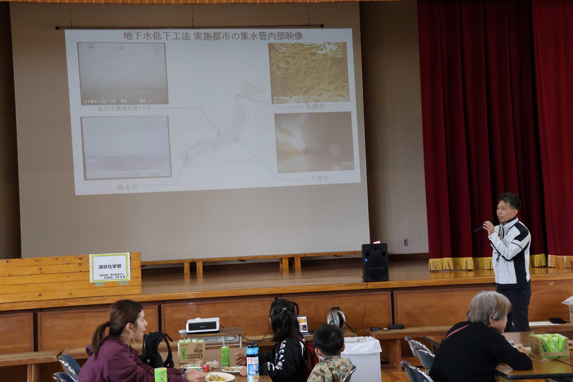 体育館では職員がスライドを使って液状化現象を解説