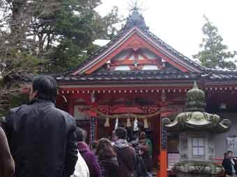 沢山の人達が列をなして並び、拝殿入口に大きな灯篭が設置されている金沢神社の写真