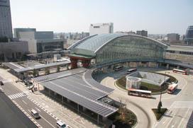 アーチを描く屋根とガラス張りの壁が特徴的な金沢駅と、その手前にあるバスロータリーの全体写真
