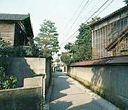 武家屋敷の建物が見える塀が続く整備された道の写真