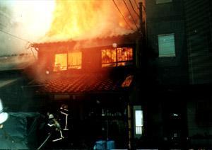火事の現場を撮影した写真。燃え上がる民家が写っている。