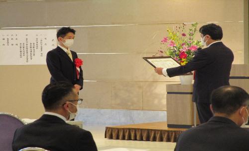 市長が表彰者と向かい合って賞状を渡そうとしている表彰式の写真