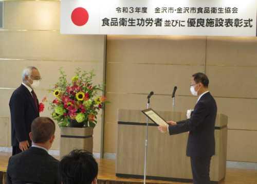 市長が表彰者と向かい合って賞状を渡そうとしている表彰式の写真