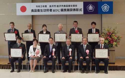 中央に市長、横と後ろに表彰状をもった表彰者たちや関係者達が12名が並んでいる記念写真