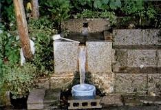 柄杓とバケツがおいてある塚崎のわき水の水汲み場の写真