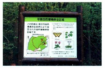 この区域は、金沢市自然環境保全条例により指定された事前環境保全区域ですという文章、地図や植物などのイラストが描かれている平栗自然環境保全区域の看板写真