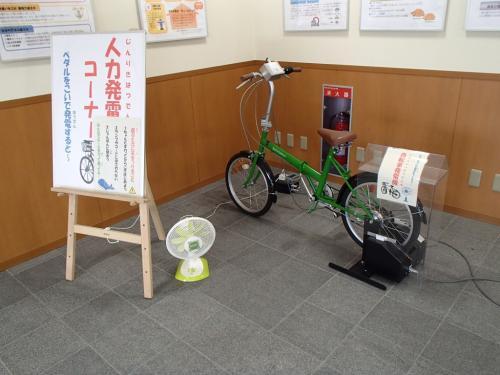 緑の自転車と扇風機が置かれている人力発電コーナーの写真