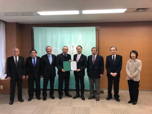 山野金沢市長を中心に関係者の男性6名と女性1名が横一列に並び、協定書を持って記念撮影をしている写真