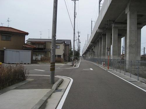 左側には道路、右側の上方には高架橋が架かっている糸田新町線の写真